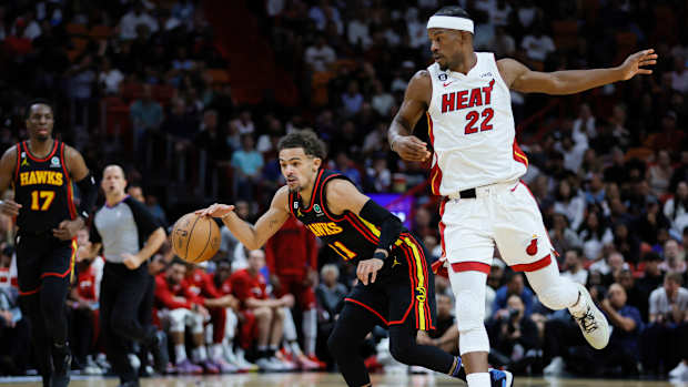 Atlanta Hawks guard Trae Young dribbles past Miami Heat forward Jimmy Butler.